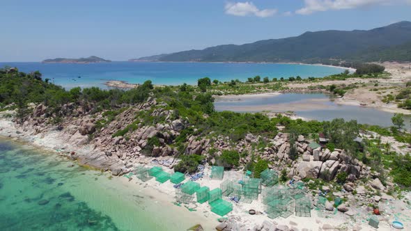 Square fishing nets on shore of Vietnam with view of Binh Tien Beach