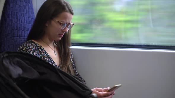 Close Shot of Young Attractive Ukraine Female in Glasses Sitting on Moving City Metro Train