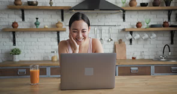 Healthy Asian Woman Using Laptop and Drinking Orange Juice Front View