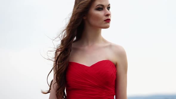 Fashion Model is Tensely Watching Standing on an Embankment Closeup