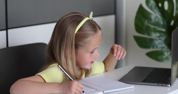 Caucasian Little Girl School Pupil Studying Online From Home Watching Web Class Lesson or Listening