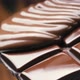 Chocolate pouring on chocolate bar on black background - VideoHive Item for Sale