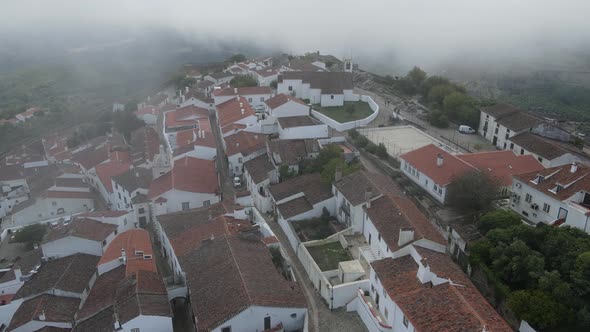 Fog flows over the village near Marvão Castle making it appear cursed and haunted.