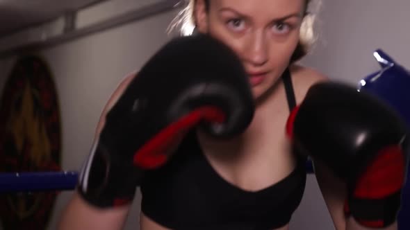 Aggressive Female Boxer Practices Punches in Training