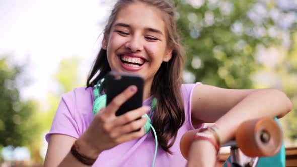 Happy Teenage Girl with Smartphone and Longboard 