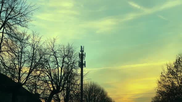 5G GSM Tower Over Evening Sky in Small Town