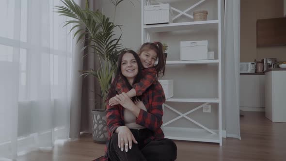 Family, Children, Love and Happy People Concept - Happy Mother and Daughter Hugging at Home