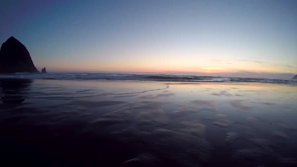 Panning time lapse of the setting sun and incoming tide at Cannon Beach.