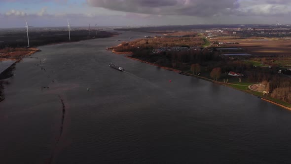 Aerial Over Oude Maas With Ship And Wind Tubrines In Background At Barendrecht. Dolly Forward Establ