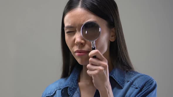 Curious Asian Woman Looking Through Magnifying Glass, Wants to See Details