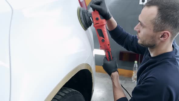 Man Polish a Car in a Garage