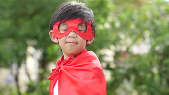 Asian Child In In Superhero Costume Playing In The Park