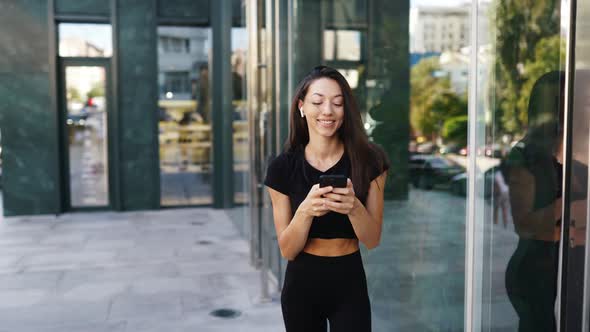 Portrait of a Young Brunette Woman with Headphones While Walking