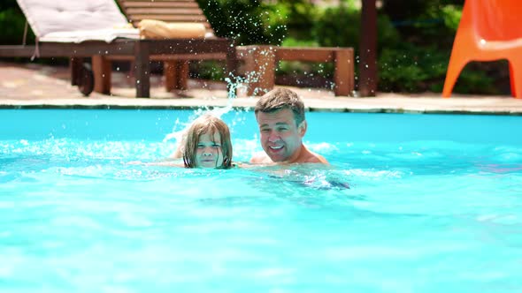 Dad Teaches His Daughter to Swim in the Pool