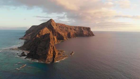 Impressive establishing scenic sunset flight above turquoise ocean sea water toward picturesque Cal