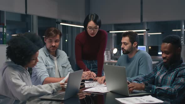 Asian Businesswoman Leading Meeting with Diverse Employees in Office