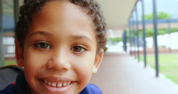 Close-up of happy disabled African American schoolboy sitting on wheelchair in school corridor 4k