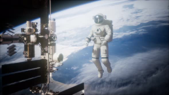 International Space Station and Astronaut in Outer Space Over the Planet Earth alt