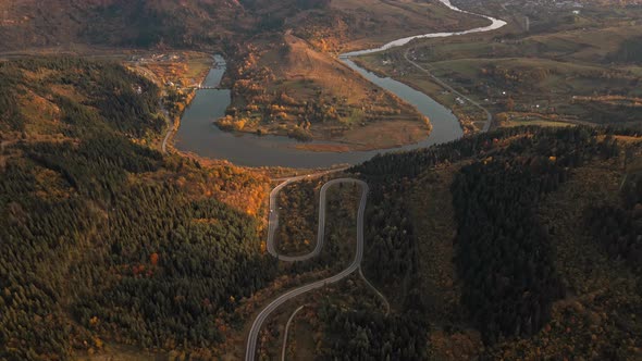 Aerial Drone View Above Winding Mountain Road Between Hills Curving River