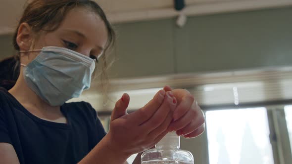 Corona pandemic - Girl using hand sanitizer to prevent coronavirus spread