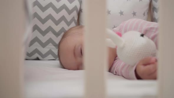 Sleep time. Portrait of a sleeping baby hugging a knitted bunny toy.