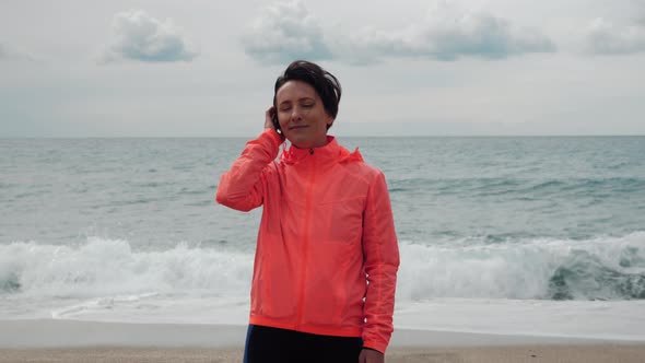 Free happy young woman is looking at camera with seascape on background