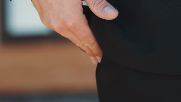 Man with Gold Wedding Ring Puts Hand Into Trousers Pocket