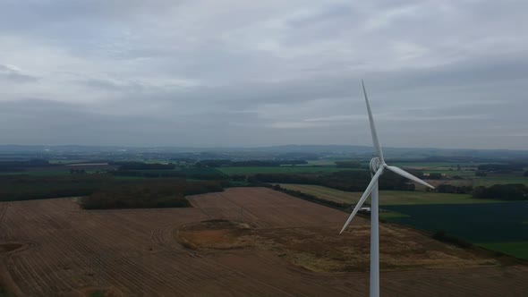 Aerial rotation around wind turbine in British countryside.