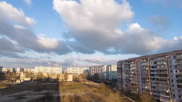 Cumulus Cirrus Clouds Move in the Blue Sky Over Multistory Buildings in City