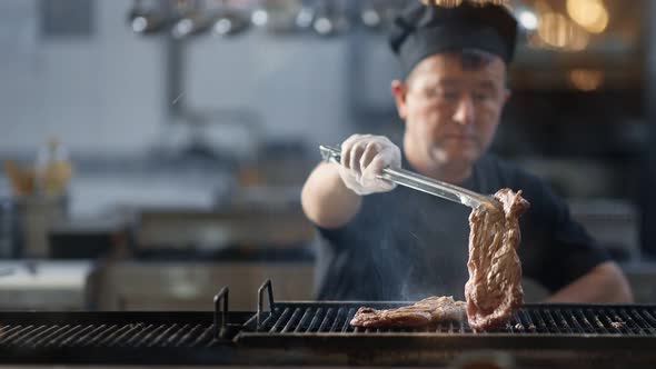 Korean Kitchener Turning Roasted Meat Fillet on Grilled