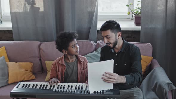 Man Teaching Boy Musical Notation