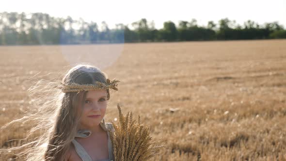 Serious Sad Girl a Child Stands on a Wheat Mown Field