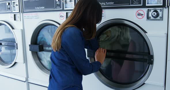 Woman looking at washing machine 