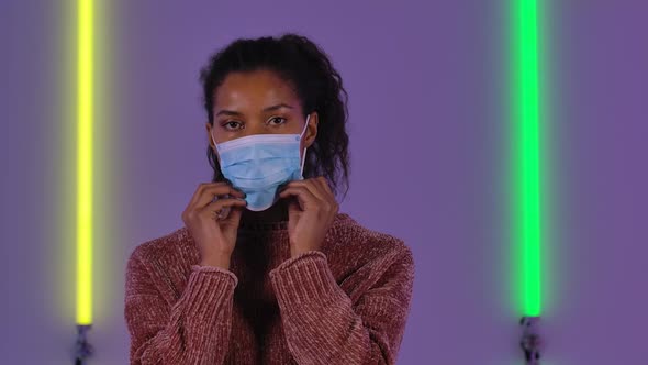 Portrait of Afro American Young Woman Puts on and Then Removes Medical Protective Mask