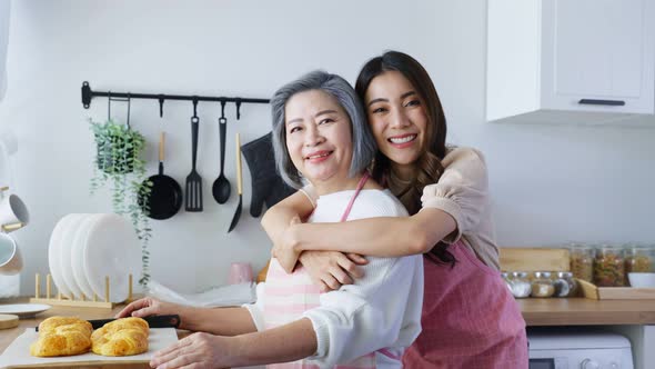 Portrait of Asian lovely family, Attractive female and senior elderly mom bake croissant in kitchen