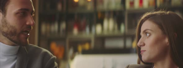 Man talking with brunette in cafe