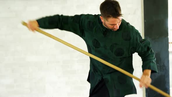 Kung fu fighter practicing martial arts with whip stick 