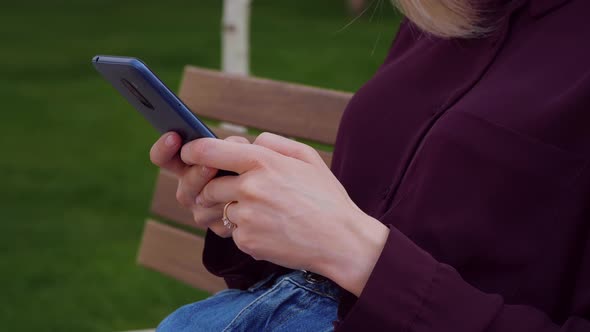 Girl Lady Hands using texting mobile phone or chat outdoor park city.