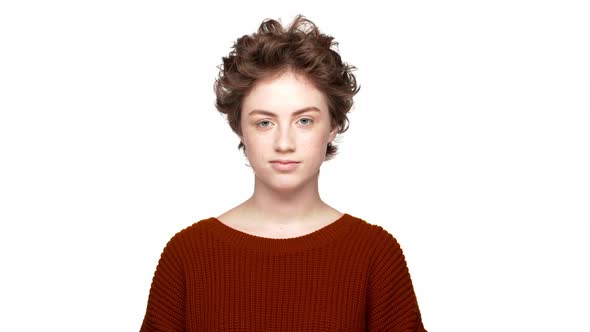 Studio Portrait of Confident Lady with Brown Curly Hair Expressing Agreement with Nodding Positively