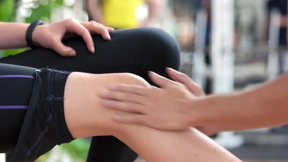 Woman Receiving Knee Massage at Gym.