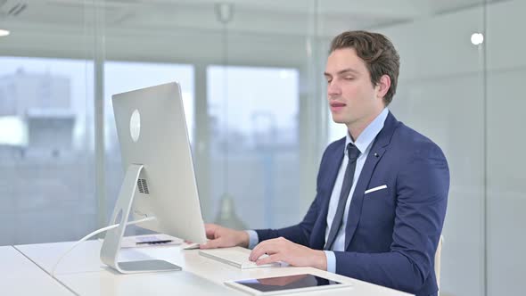 Ambitious Young Businessman Showing Thumbs Up in Office 