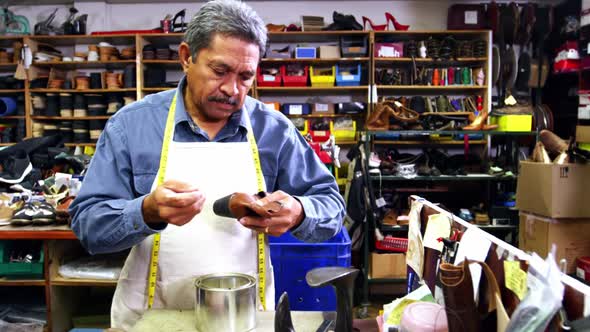 Cobbler applying glue on shoe