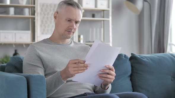 Gray Hair Man Reading Documents While Sitting on Sofa, Paperwork