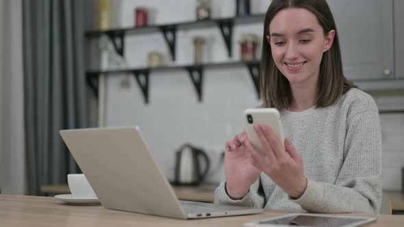 Young Woman Using Smartphone in Living Room