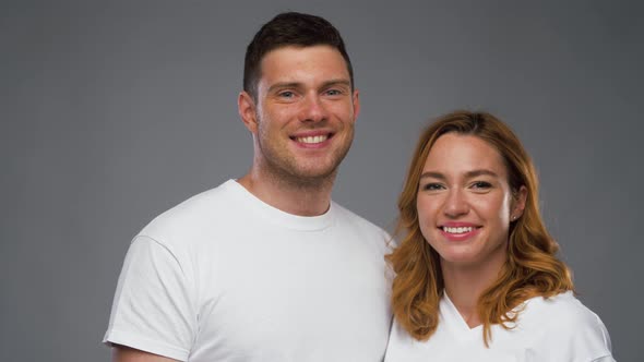 Couple in White T-shirts Over Grey Background