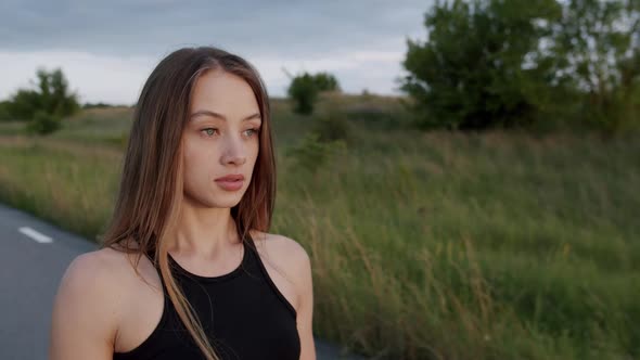 Portrait of Athletic Girl Looking Purposefully at Camera at Summer Nature