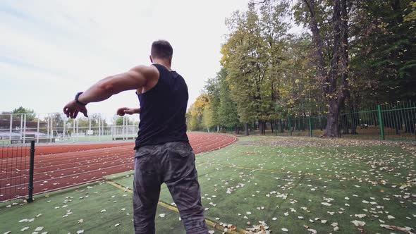 Male fitness sportsman training his body on the stadium