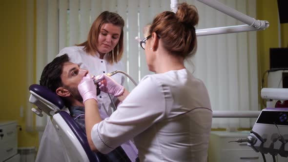 Stomatologist Polishing Teeth To Patient in Clinic