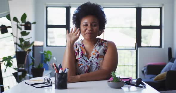 African american female plus size vlogger sitting using laptop having a video chat