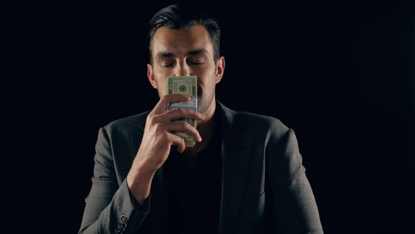 Handsome man plays with a stack of cash